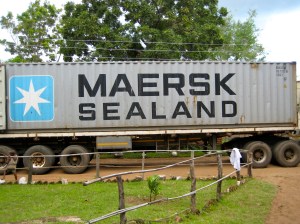 40 foot container backing up dirt road at hospital